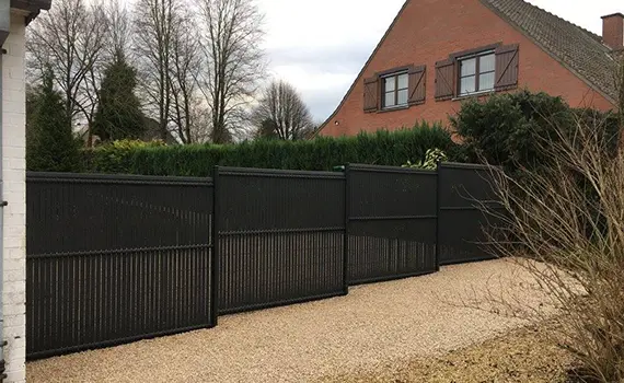 Clôture noire entourée d'une allée bien entretenue