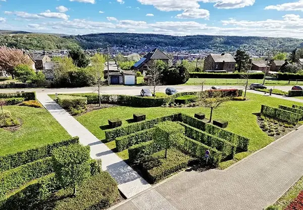 Perspective aérienne d'un jardin avec des haies et des arbres, illustrant un aménagement paysager esthétique et soigné.